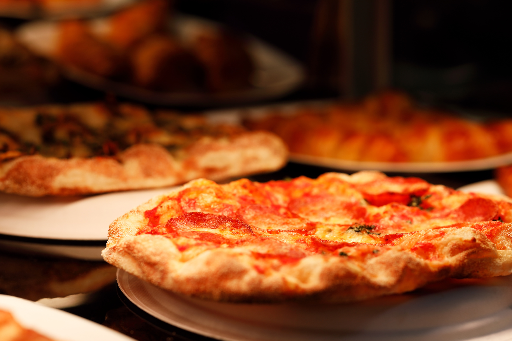 fresh-baked pizzas on pizzeria restaurant counter